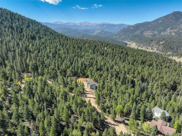 birds eye view of property with a mountain view and a wooded view