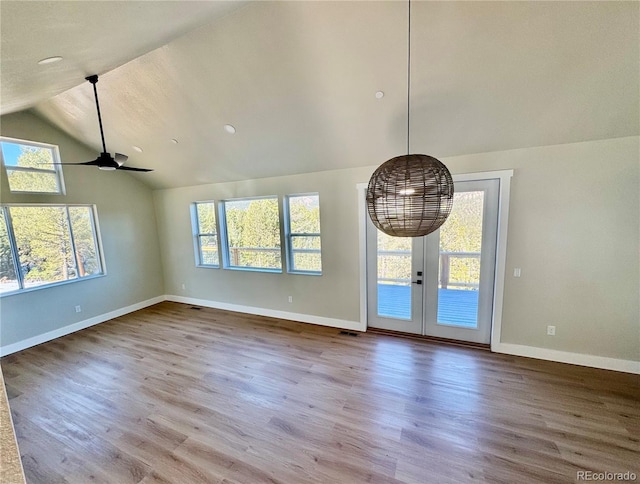 unfurnished living room with visible vents, a ceiling fan, wood finished floors, baseboards, and vaulted ceiling