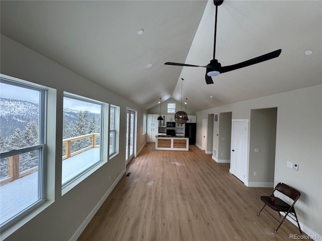 unfurnished living room featuring visible vents, baseboards, lofted ceiling, ceiling fan, and light wood-type flooring