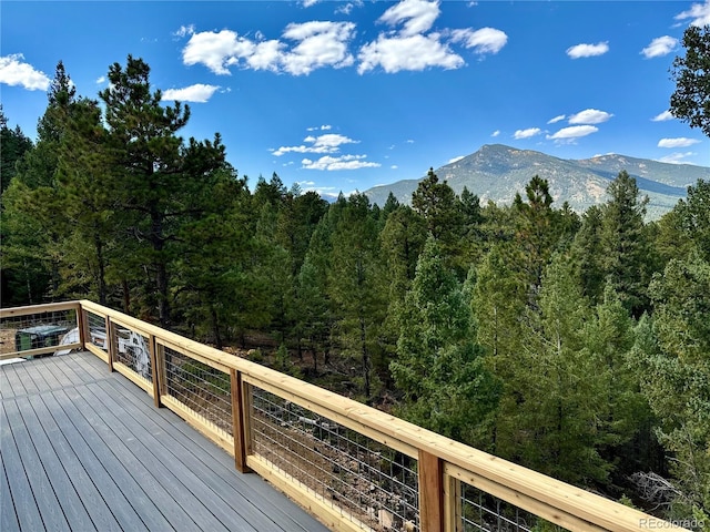 deck featuring a mountain view and a forest view