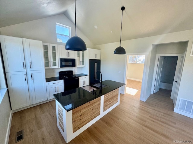 kitchen featuring black appliances, light wood-type flooring, a sink, and visible vents