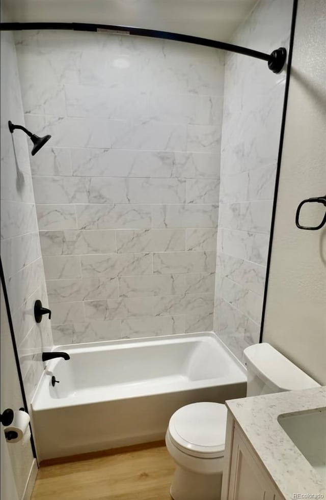 bathroom featuring shower / bath combination, vanity, toilet, and wood finished floors