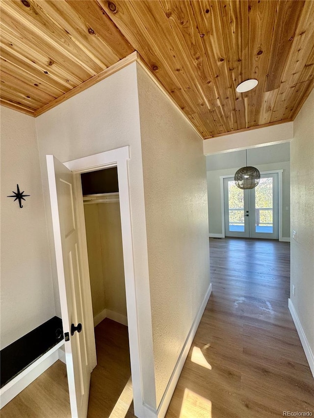 hallway with wood ceiling, baseboards, wood finished floors, and french doors