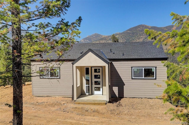 view of front facade with roof with shingles and a mountain view