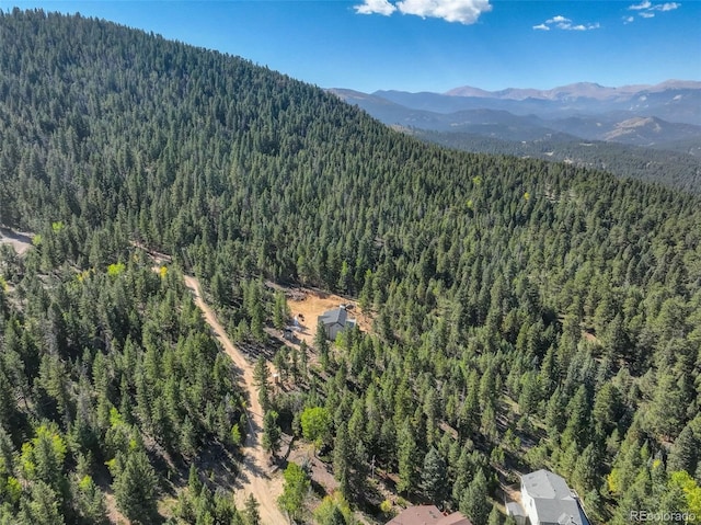 birds eye view of property featuring a forest view and a mountain view