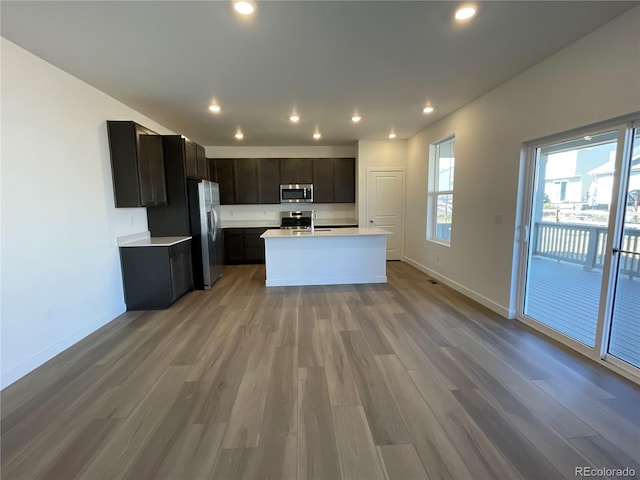 kitchen featuring hardwood / wood-style floors, sink, stainless steel appliances, and a kitchen island with sink