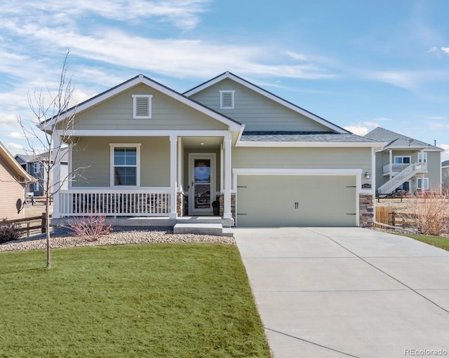 view of front of house with covered porch, driveway, a front lawn, and an attached garage