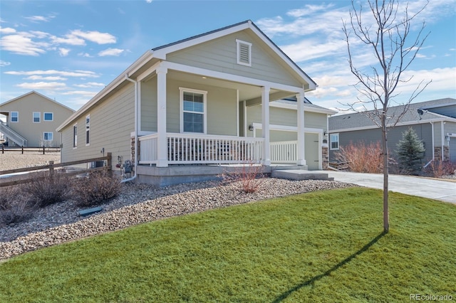 view of front facade featuring a porch, a front yard, and driveway