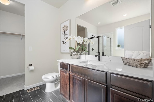 full bathroom featuring toilet, a stall shower, visible vents, and vanity