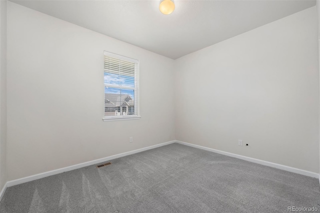 carpeted empty room featuring visible vents and baseboards