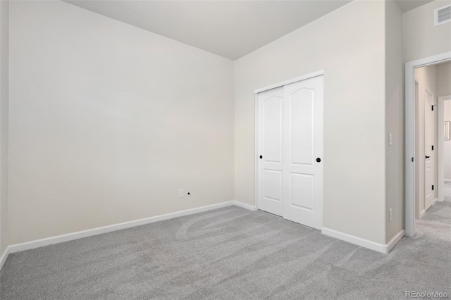 unfurnished bedroom with carpet, a closet, and baseboards