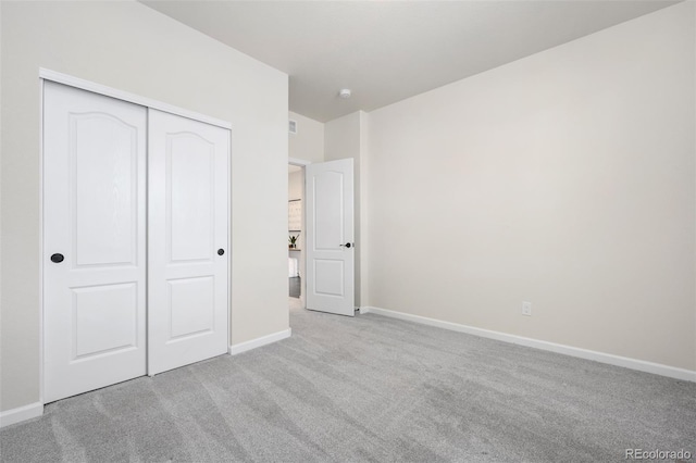 unfurnished bedroom with carpet floors, a closet, and baseboards