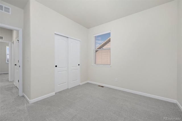 unfurnished bedroom featuring a closet, baseboards, visible vents, and carpet flooring