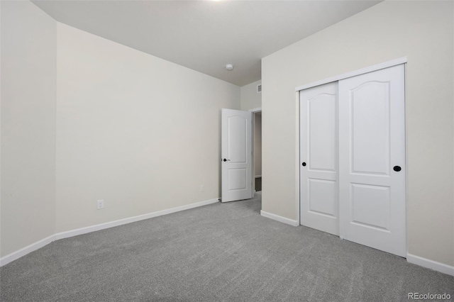 unfurnished bedroom with carpet floors, a closet, and baseboards