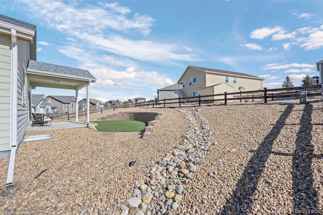 view of yard with a patio area, a fenced backyard, and a residential view