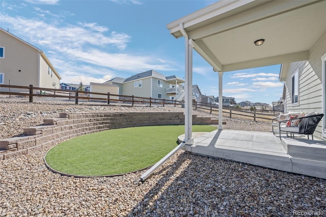 view of yard with a residential view, a fenced backyard, and a patio