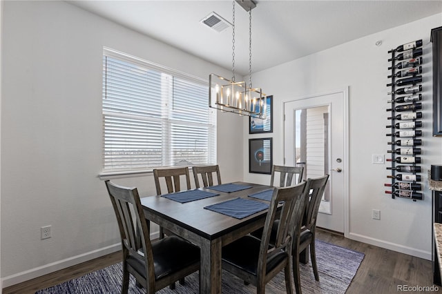 dining space with an inviting chandelier, baseboards, dark wood finished floors, and visible vents