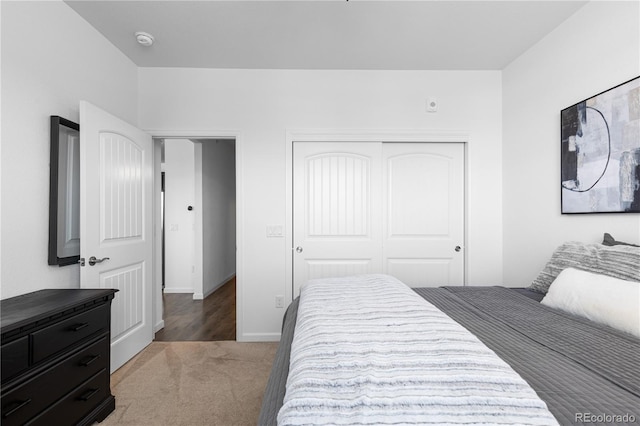 bedroom featuring a closet, baseboards, and carpet