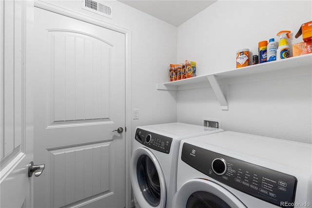 laundry area with laundry area, separate washer and dryer, and visible vents
