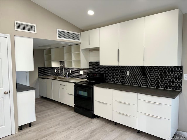 kitchen featuring light hardwood / wood-style floors, sink, black range with electric cooktop, lofted ceiling, and white cabinetry