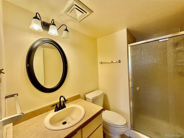 bathroom featuring vanity, walk in shower, toilet, and a textured ceiling