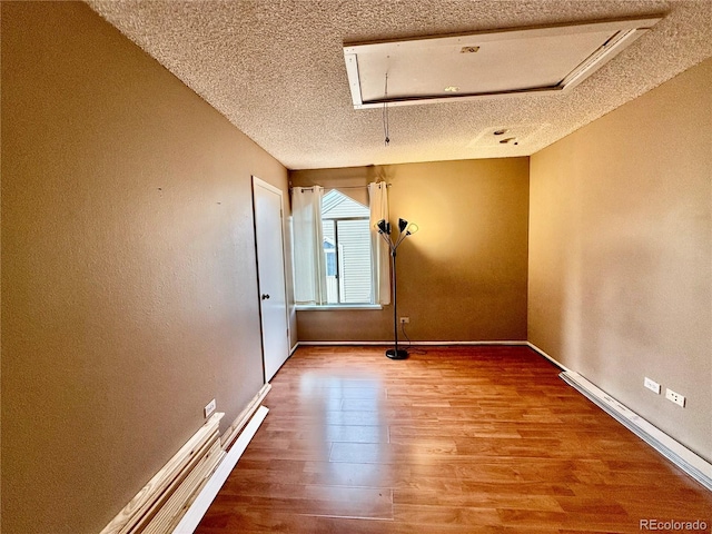 3414 S Locust St Unit D, Denver, CO 80222 - empty room featuring attic access, a textured ceiling, and wood finished floors