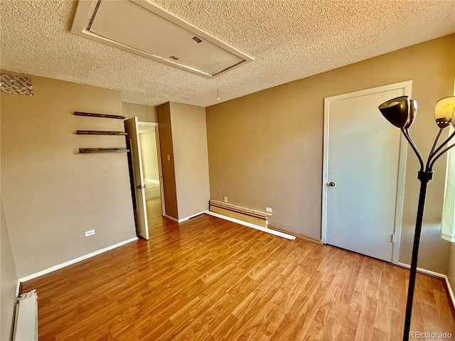 3414 S Locust St Unit D, Denver, CO 80222 - unfurnished bedroom featuring attic access, a textured ceiling, and wood finished floors