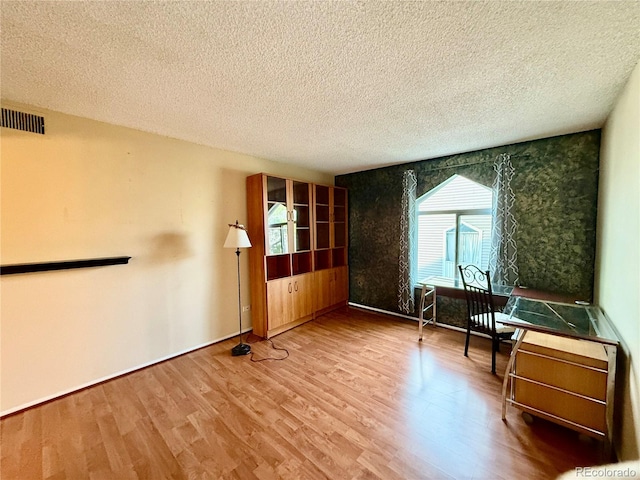 spare room featuring hardwood / wood-style floors and a textured ceiling