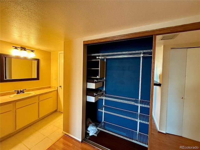 interior space with vanity, a textured ceiling, and hardwood / wood-style floors