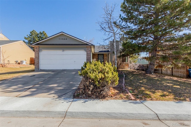 single story home featuring brick siding, concrete driveway, an attached garage, and fence