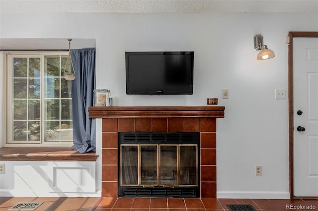 room details with baseboards, a fireplace, visible vents, and a textured ceiling