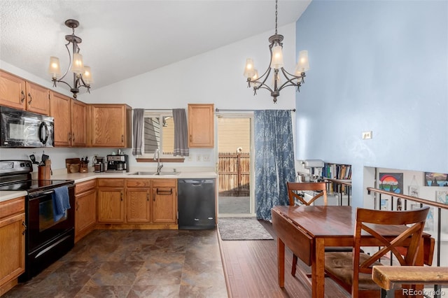 kitchen with a sink, a notable chandelier, black appliances, and light countertops