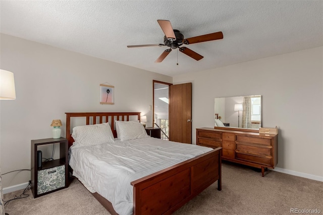 bedroom featuring light carpet, a textured ceiling, and baseboards