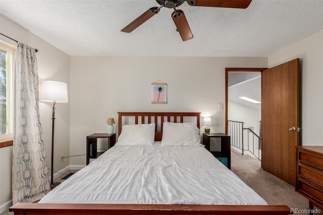 carpeted bedroom featuring baseboards, a textured ceiling, and ceiling fan