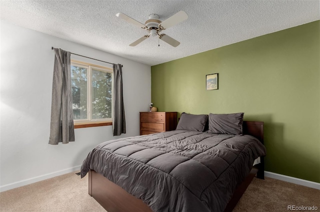 carpeted bedroom featuring a textured ceiling, baseboards, and a ceiling fan