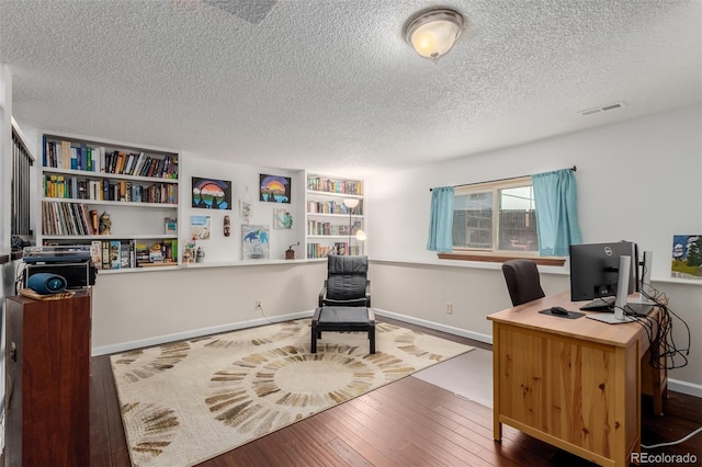 office space featuring visible vents, a textured ceiling, and hardwood / wood-style floors