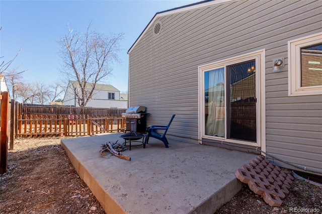 view of patio featuring a fire pit, a grill, and fence