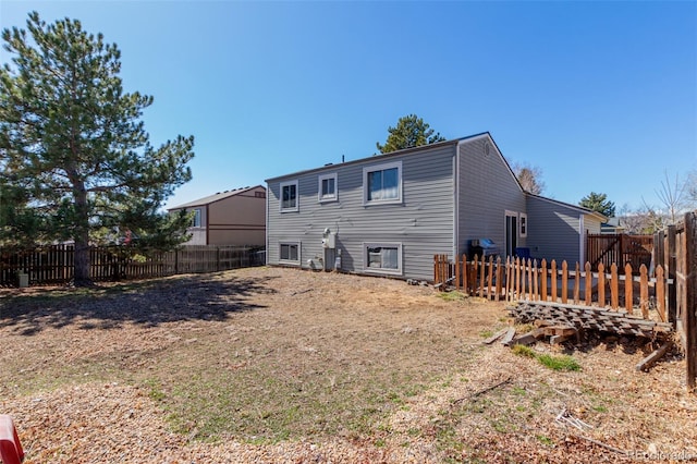 rear view of house with a fenced backyard