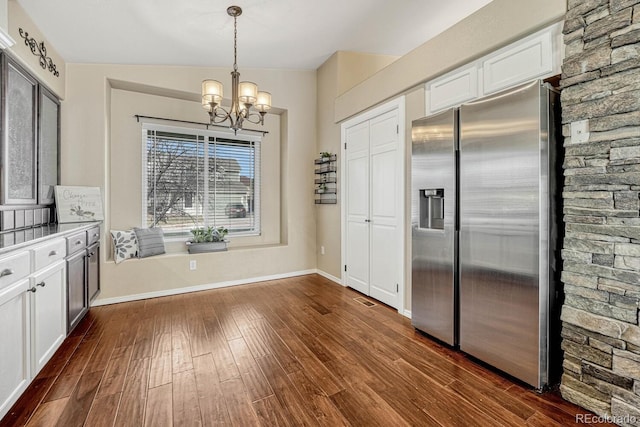 kitchen featuring white cabinetry, dark hardwood / wood-style floors, stainless steel fridge, a chandelier, and decorative light fixtures