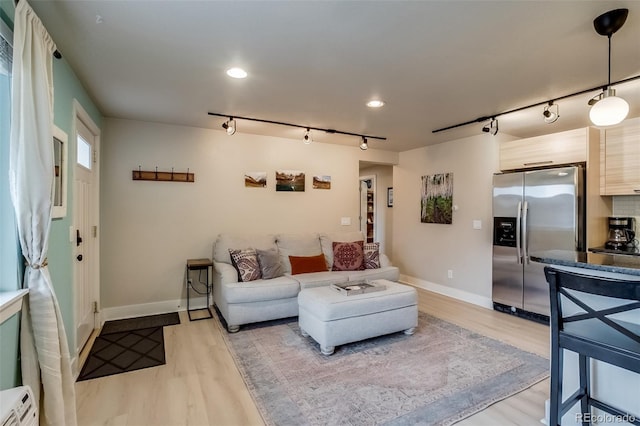 living area featuring recessed lighting, baseboards, and light wood finished floors