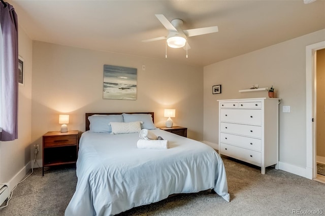 bedroom with a baseboard heating unit, carpet flooring, baseboards, and a ceiling fan