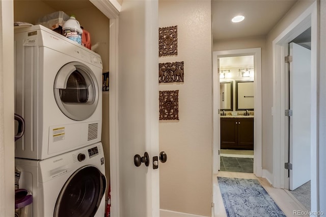 washroom featuring a sink and stacked washer / dryer