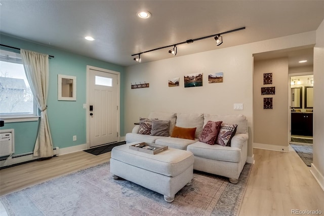 living room featuring baseboards, rail lighting, light wood-style flooring, and recessed lighting