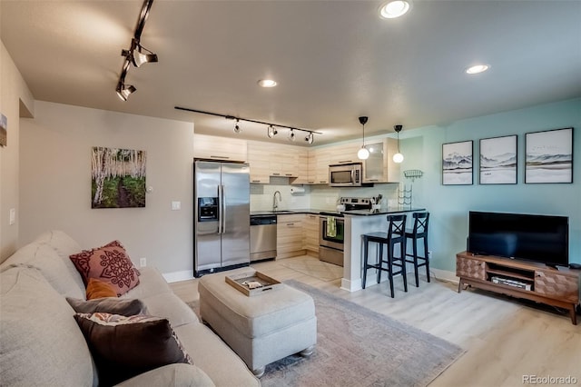 living room with light wood-type flooring and recessed lighting