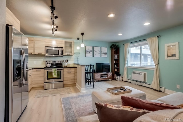 kitchen featuring a wall unit AC, dark countertops, a baseboard radiator, stainless steel appliances, and backsplash