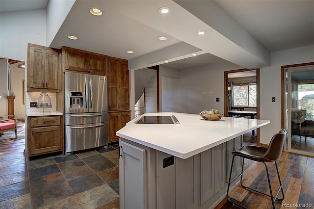 28051 Camel Heights Cir, Evergreen, CO 80439 - kitchen with stainless steel refrigerator with ice dispenser, black electric cooktop, recessed lighting, light countertops, and a kitchen island