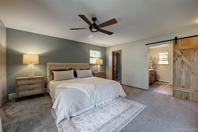 28051 Camel Heights Cir, Evergreen, CO 80439 - carpeted bedroom with a barn door, baseboard heating, a spacious closet, a baseboard radiator, and ceiling fan