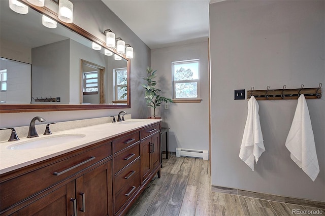 28051 Camel Heights Cir, Evergreen, CO 80439 - bathroom featuring baseboard heating, wood finished floors, and double vanity