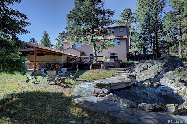28051 Camel Heights Cir, Evergreen, CO 80439 - view of grassy yard featuring a wooden deck, stairway, a fire pit, and a small pond