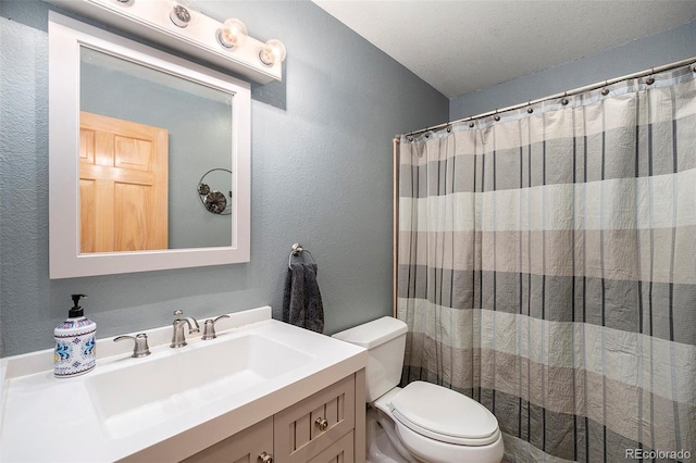 full bathroom with a textured wall, toilet, vanity, and a shower with shower curtain
